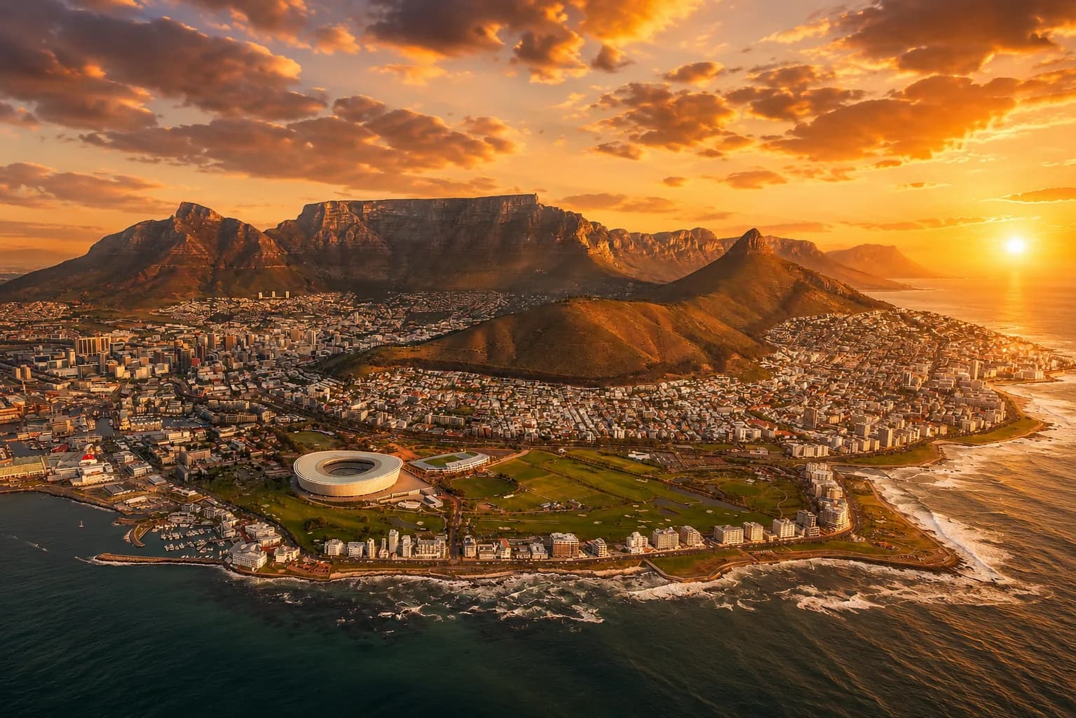 Aerial sunset view of Cape Town, Table Mountain and the Atlantic coastline.